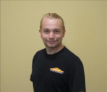 Male employee with blonde hair in front of gray background